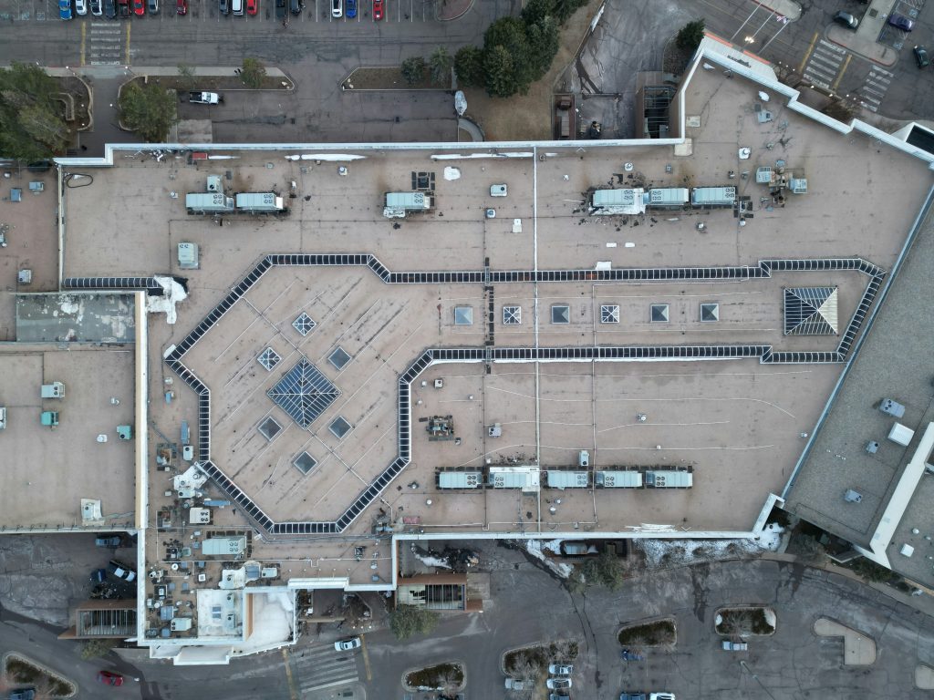 Symbolbild: Drohnenaufnahme eines Gewerbeflachdachs mit technischen Aufbauten